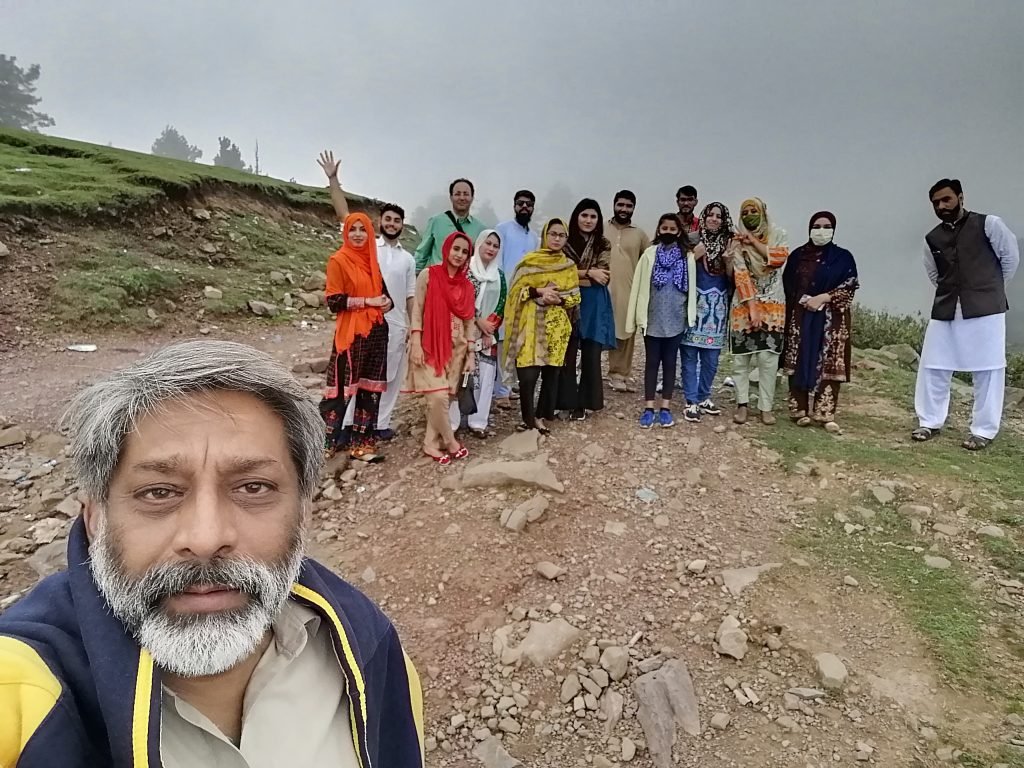 Geography department field trip group atop a misty ridge in Kuttan, AJK