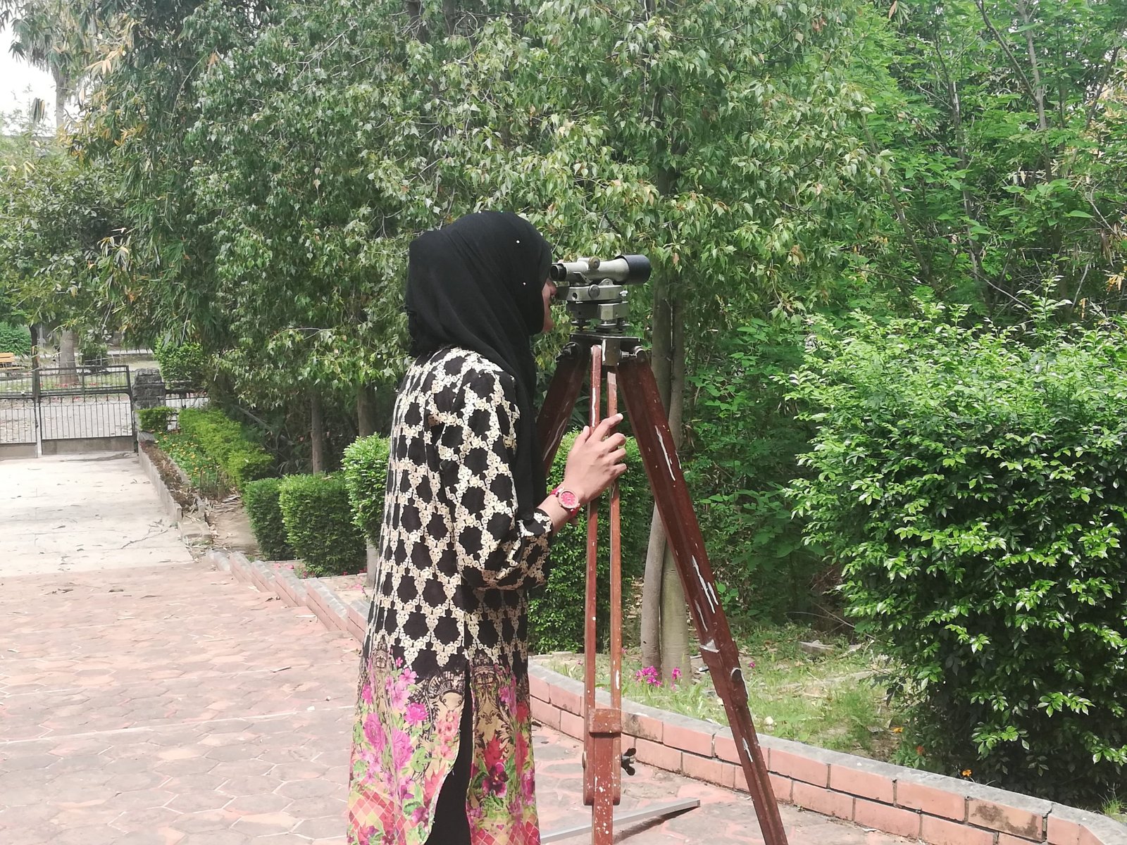 A student sighting through the theodolite during a practical surveying exercise